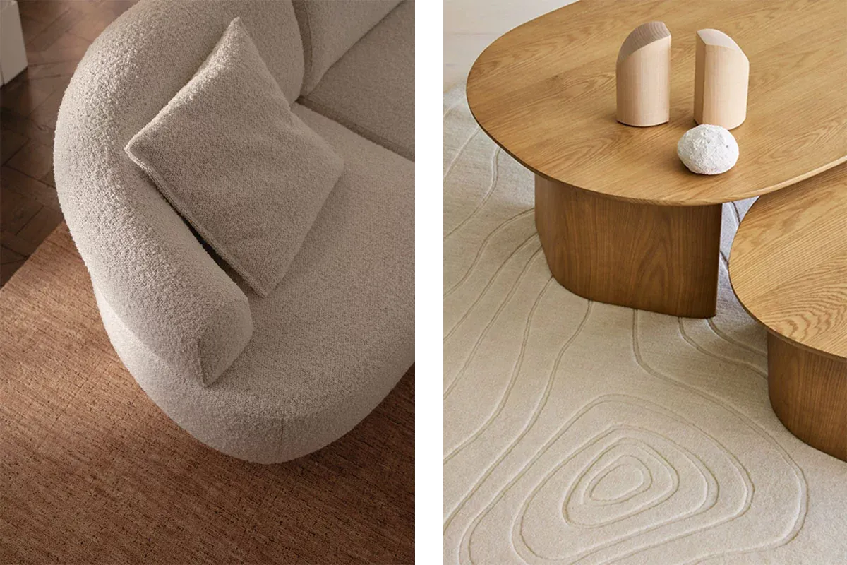 A curved cream boucle sofa on a wool rug, beside two rounded oak coffee tables with organic shapes