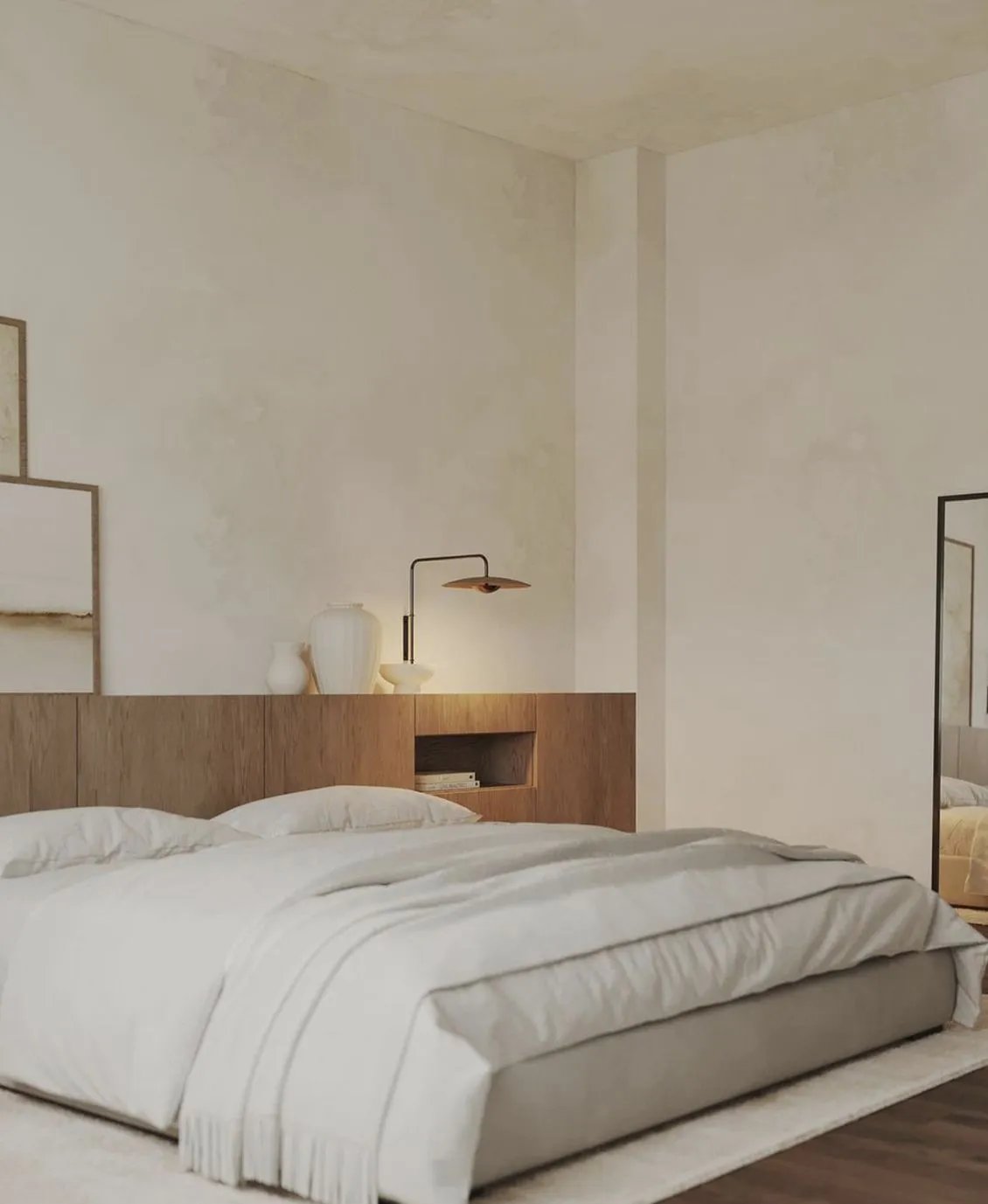Upholstered double bed against a full width oak headboard panel with a built-in niche, a full length mirror on the wall beside it.