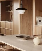 Oak kitchen with a marble worktop run, an island with an induction hob and two pendant lights over the dining table.