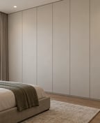 Made-to-measure wardrobe from floor to ceiling with matte handleless doors, in a bedroom in Tirana.
