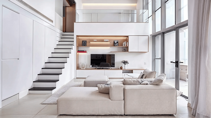 Double height living room with a built-in oak and white media wall, handleless fronts and a low cream sectional.