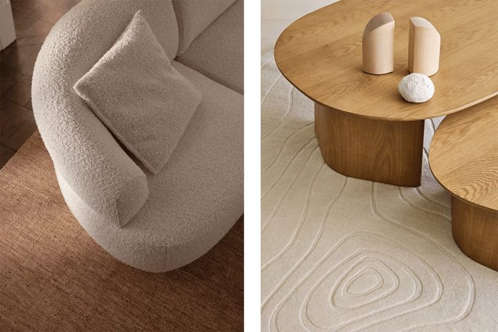 A curved cream boucle sofa on a wool rug, beside two rounded oak coffee tables with organic shapes