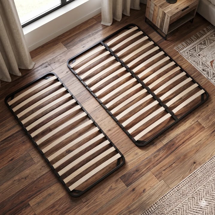 Two slatted bases with black metal frames and curved wooden slats, the wider one with a centre rail, on a wooden floor