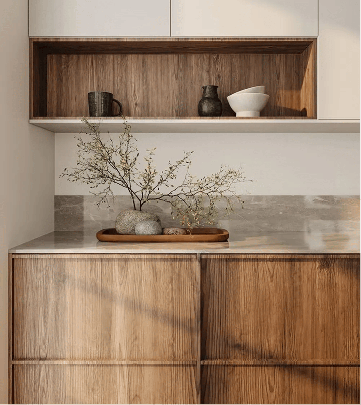 Walnut cabinets with an open niche holding hand thrown ceramics above a honed stone worktop.