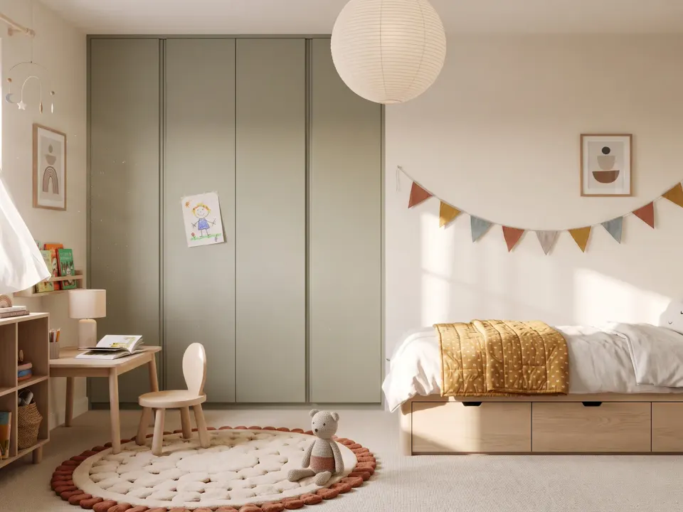 Child’s room with a sage green fitted wardrobe, an oak single bed with three drawers, a small desk and a low bookcase