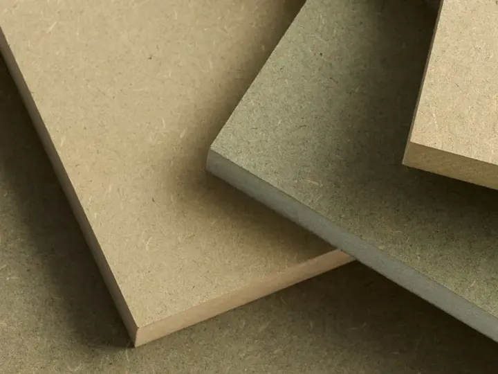 Raw and moisture-resistant MDF panels stacked in a workshop
