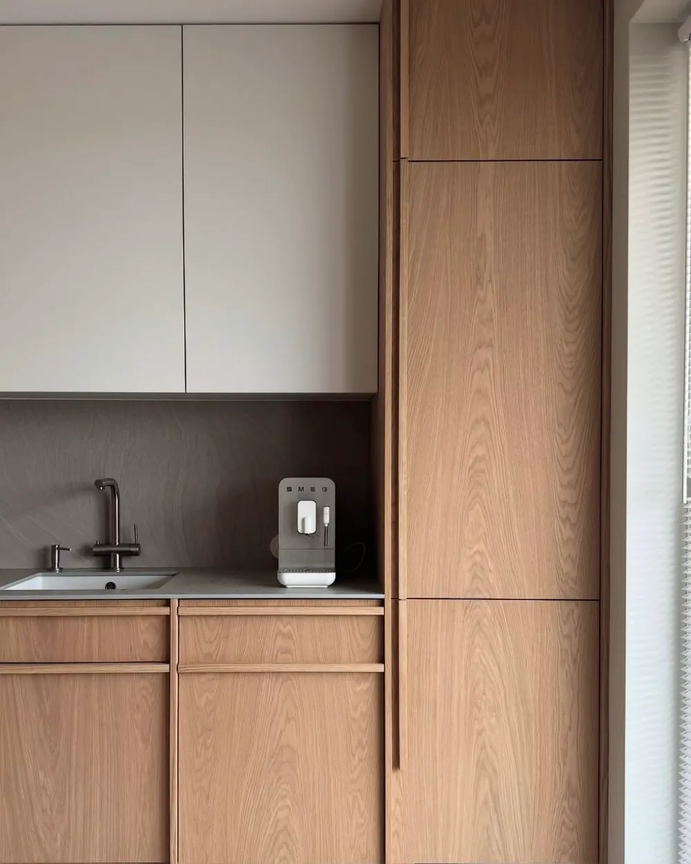 Full-height oak cabinetry running from the kitchen into the living area of an apartment