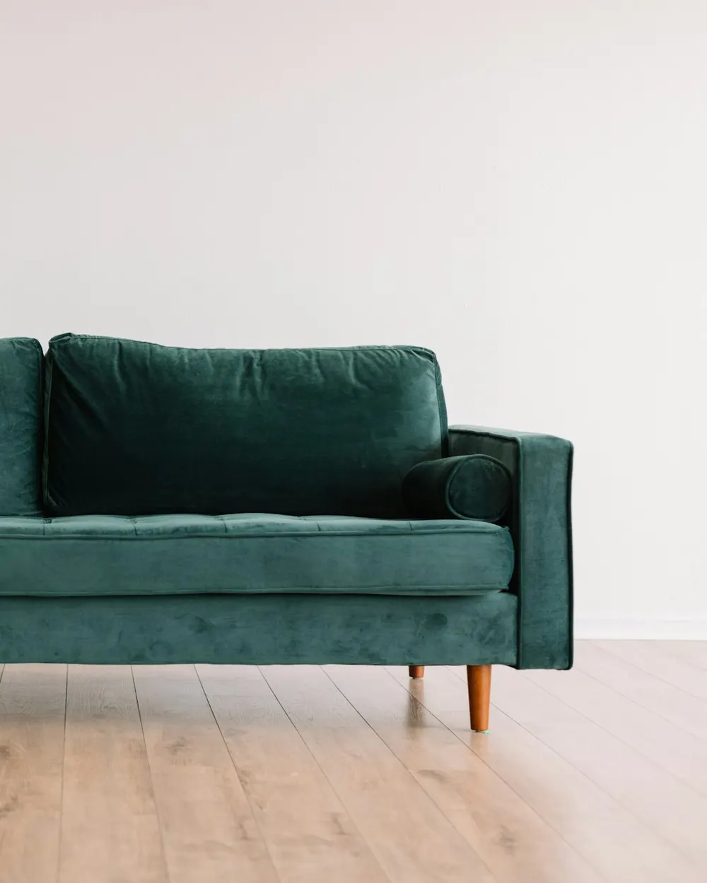 Green velvet sofa on a light wood floor in a café lounge